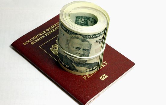 Stack of paper usa dollars and red passport under