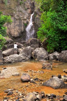 Man taking photo of waterfall