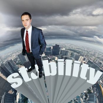 Businessman in suit standing on the word stability