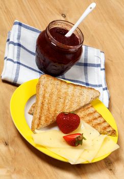 Breakfast Set with Cheese, Strawberries, Jam and Toasts closeup on wooden background