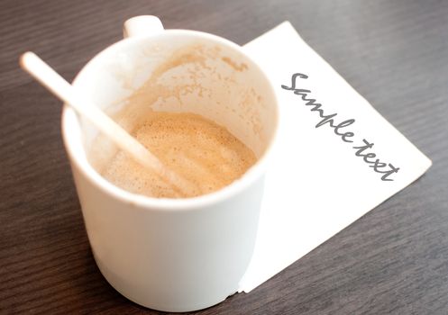 Empty cup of coffee  with white napkin space for text
on wood table