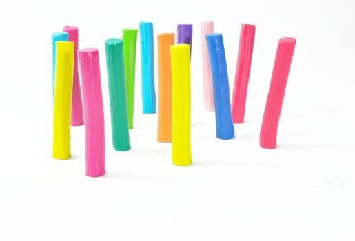 Colorful plasticine stick stand on white background