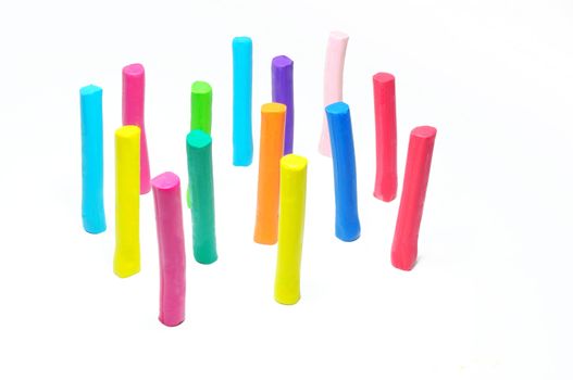 Colorful plasticine stick stand on white background