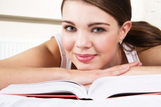 Young beautiful woman reading a book in bed 