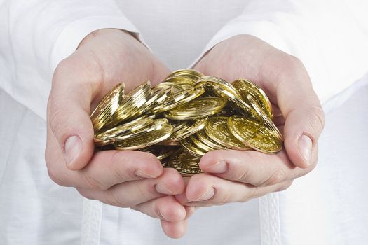 Close-up photograph of man's hands holding golden coins.