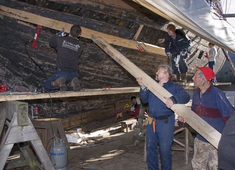 HELLEVOETSLUIS,HOLLAND-AUGUST 31:Unidentified people bending wood in the dry dock for renovation of russian frigat,on August 31,2012 in Hellevoetsluis,Holland.This renovation is only once in 13 years.