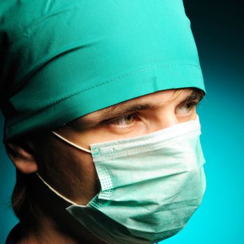 Surgeon in mask over blue