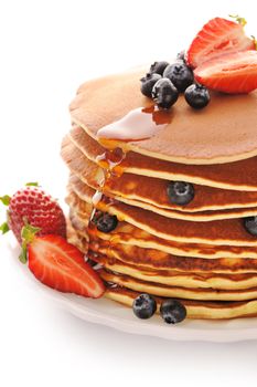 Delicious freshly prepared pancakes with strawberry and blueberries isolated on white