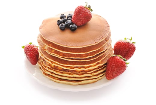 Delicious freshly prepared pancakes with strawberry and blueberries isolated on white