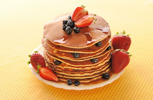 Delicious freshly prepared pancakes with strawberry and blueberries