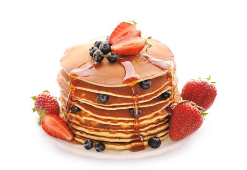 Delicious freshly prepared pancakes with strawberry and blueberries isolated on white
