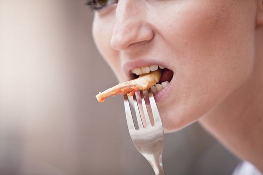 young woman is eating a pizza in restaurant outdoor