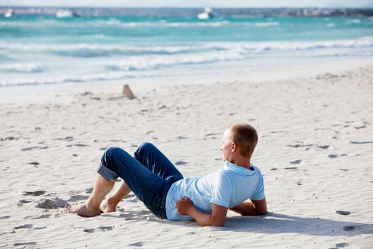 young man is relaxing on beach in summer vacation freedom