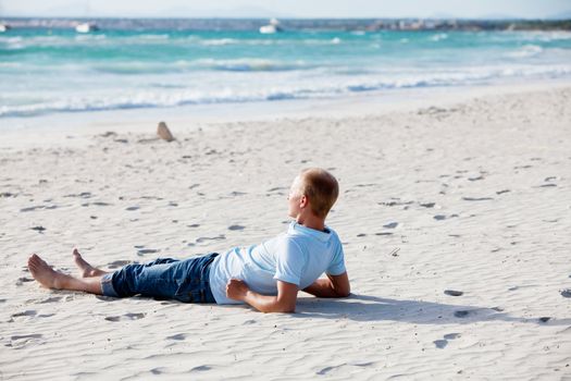 young man is relaxing on beach in summer vacation freedom