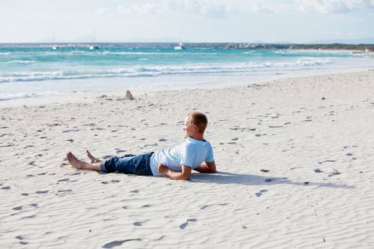 young man is relaxing on beach in summer vacation freedom