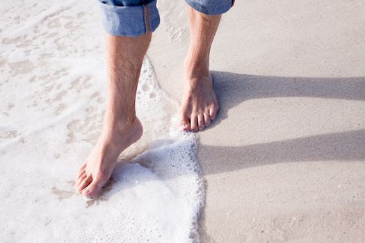 barefoot in sand and water on beach  in summer holidays relaxing