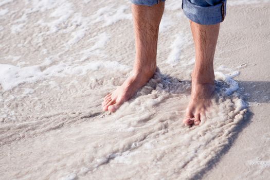 barefoot in sand and water on beach  in summer holidays relaxing