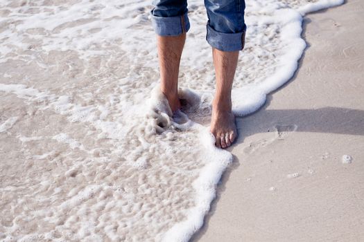 barefoot in sand and water on beach  in summer holidays relaxing