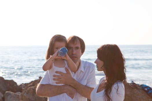 happy young family with daughter on beach in summer lifestyle