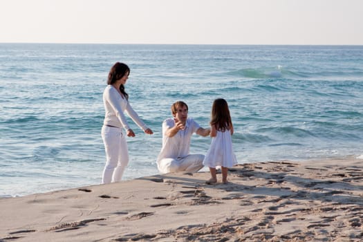 happy young family with daughter on beach in summer lifestyle