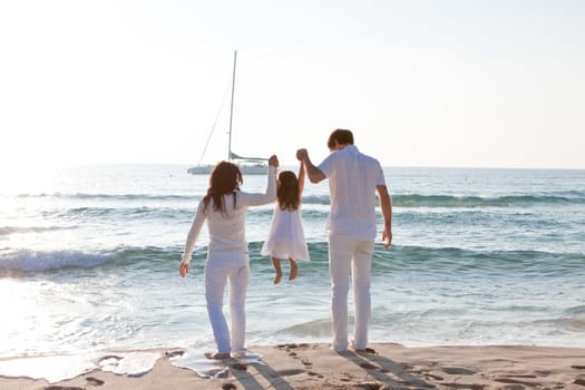 happy young family with daughter on beach in summer lifestyle