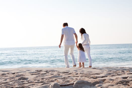 happy young family with daughter on beach in summer lifestyle