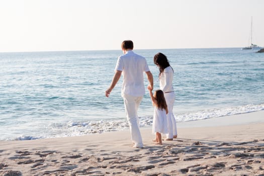 happy young family with daughter on beach in summer lifestyle