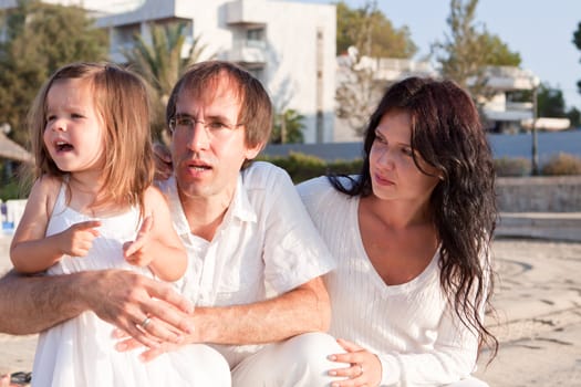 happy young family with daughter on beach in summer lifestyle