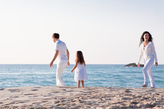 happy young family with daughter on beach in summer lifestyle