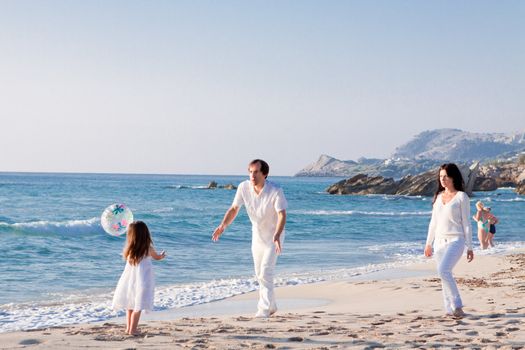 happy young family with daughter on beach in summer lifestyle