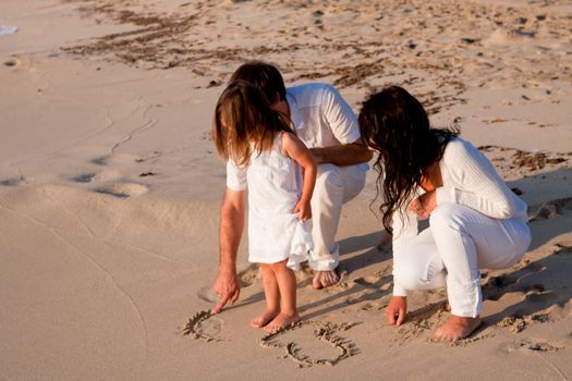 happy young family with daughter on beach in summer lifestyle