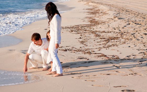 happy young family with daughter on beach in summer lifestyle