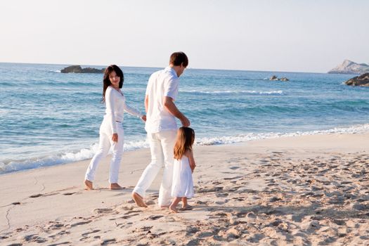 happy young family with daughter on beach in summer lifestyle