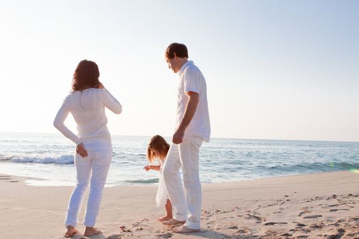 happy young family with daughter on beach in summer lifestyle