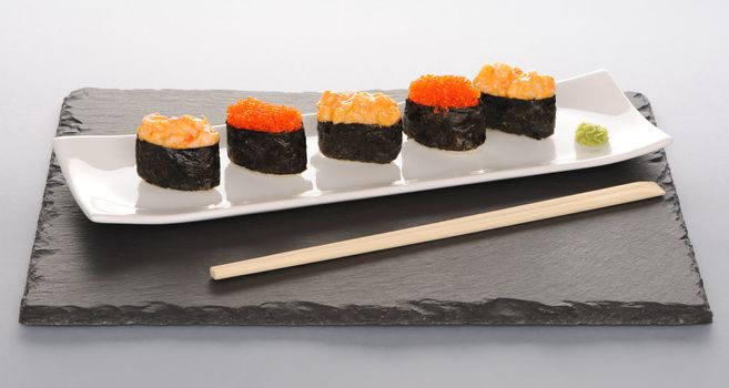 Tobiko and spice sushi on a slate plate