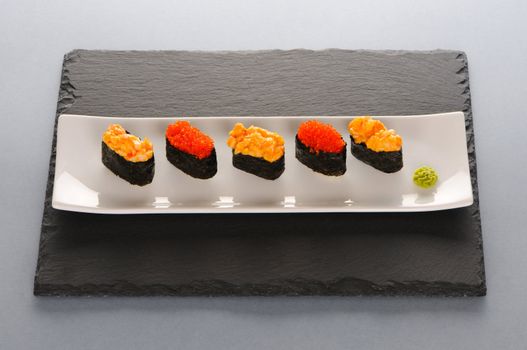 Tobiko and spice sushi on a slate plate