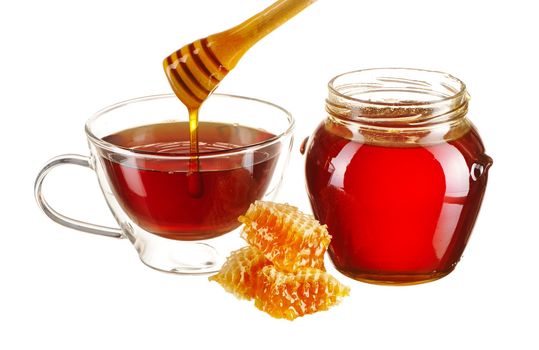 Jar of honey and tea cup isolated over white
