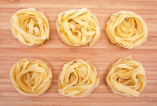 Pasta tagliatelle on the wooden background