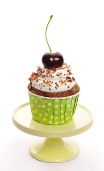 Cupcake with whipped cream and cherry isolated on white