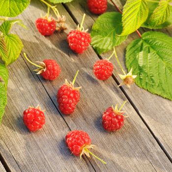 Raspberry with leafs on wooden table