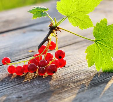 Redcurrant with leafs on wooden table