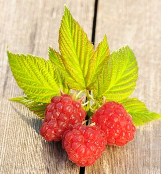 Raspberry with leafs on wooden table
