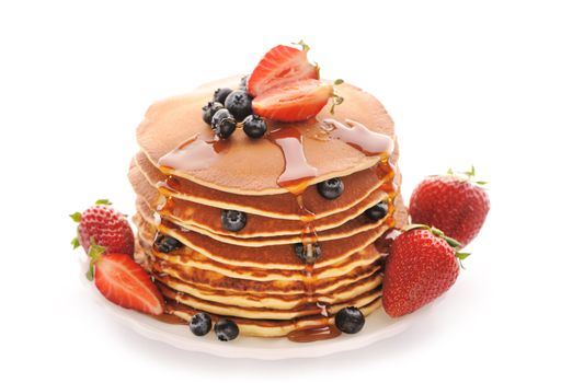Delicious freshly prepared pancakes with strawberry and blueberries isolated on white