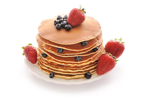 Delicious freshly prepared pancakes with strawberry and blueberries isolated on white