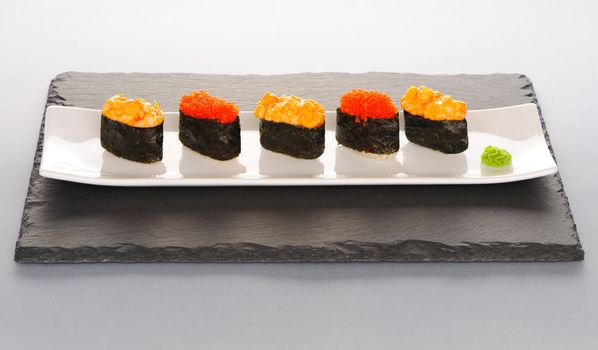 Tobiko and spice sushi on a slate plate