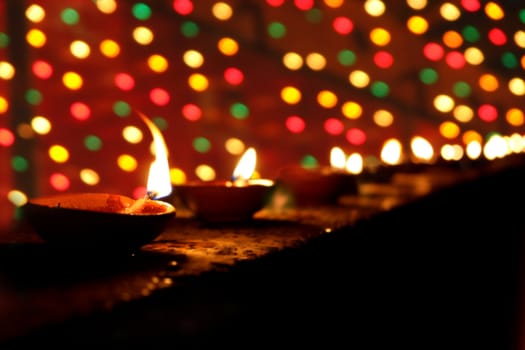 Beautiful clay lamps lit in a line on the occasion of Diwali festival in India.