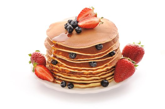 Delicious freshly prepared pancakes with strawberry and blueberries isolated on white