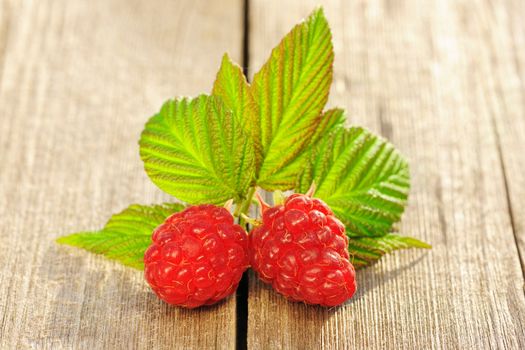 Raspberry with leafs on wooden table
