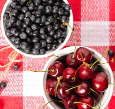 Wild berries in bowls - blueberry, cherry