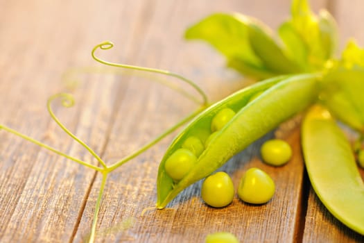 Fresh green peas pods on a wooden table
